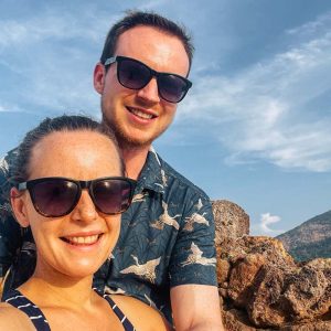 Simbur Travel Instagram profile picture, Katie & Matt sitting against a rock in Koh Lipe, Thai islands